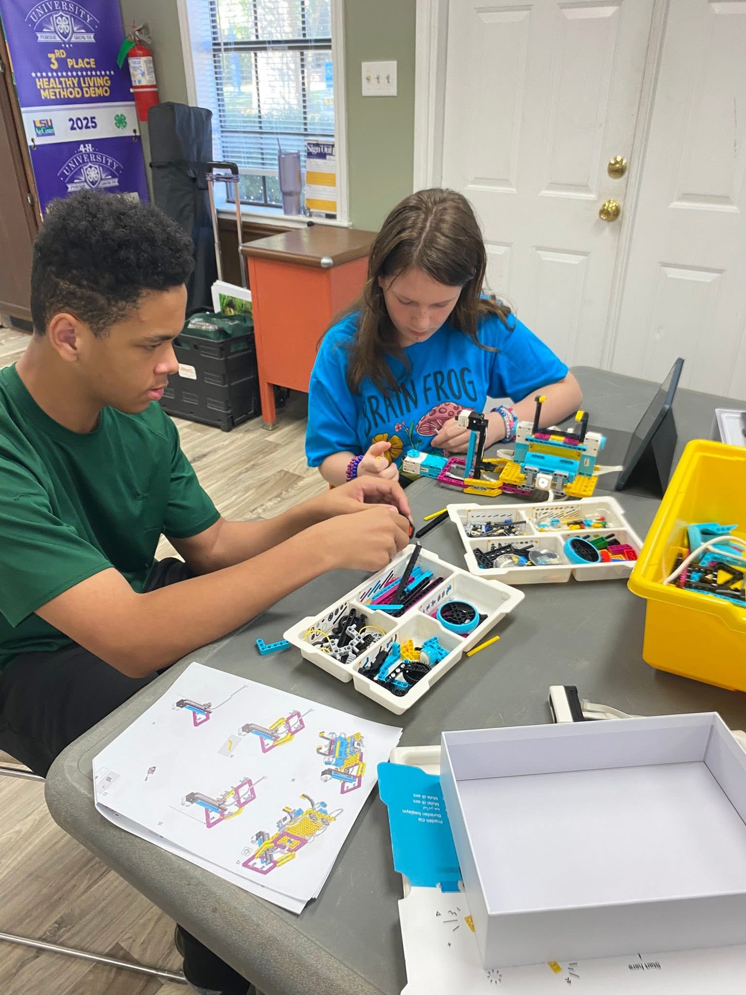 a boy and a girl building a robot